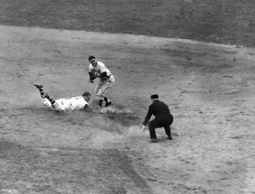 Boston Braves catcher Phil Masi slides safely back to second under Lou Boudreau, Cleveland shortstop, after being trapped off base by Cleveland pitcher Bob Feller in the eighth inning of the World Series opener in Boston's Braves Field on Oct. 6, 1948. Umpire Bill Steward calls the play. Masi scored on the next play when Tommy Holmes singled to left field, enabling the Braves to beat the Indians, 1-0. (AP Photo)